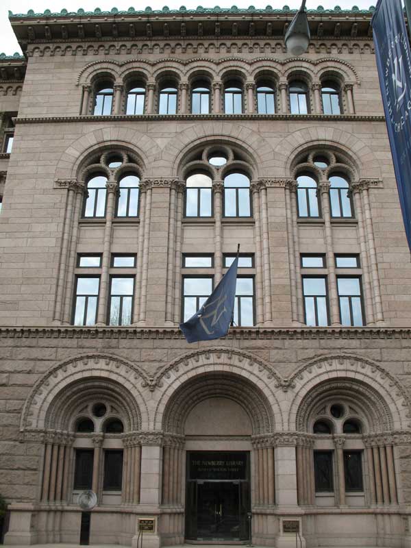 The exterior of the Newberry Library in Chicago, IL. The historic building features classic architecture with large windows and ornate details.